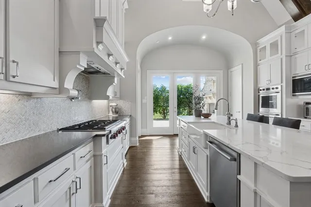 a kitchen with stainless steel appliances granite countertop a stove and a sink