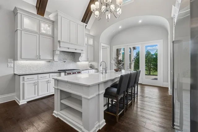 a kitchen with cabinets a sink dishwasher a dining table and chairs with wooden floor