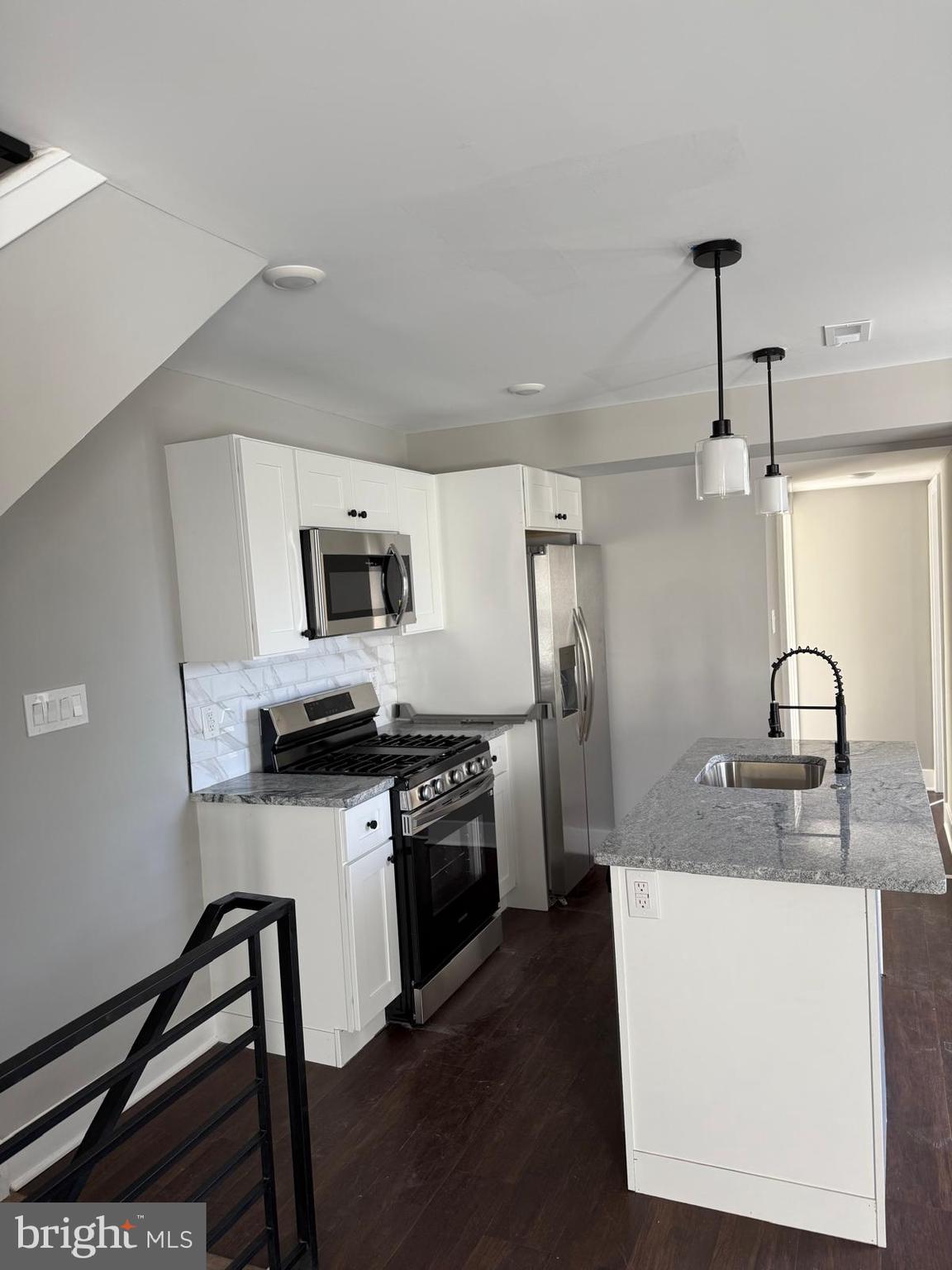 334 Church Road, Unit 2 Elkins Park, PA 19027 - Photo 18 of 38 a kitchen with stainless steel appliances granite countertop a sink a stove top oven a refrigerator with white cabinets and wooden floor