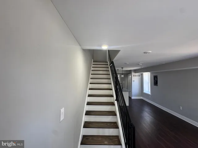 a view of a hallway with stairs and wooden floor
