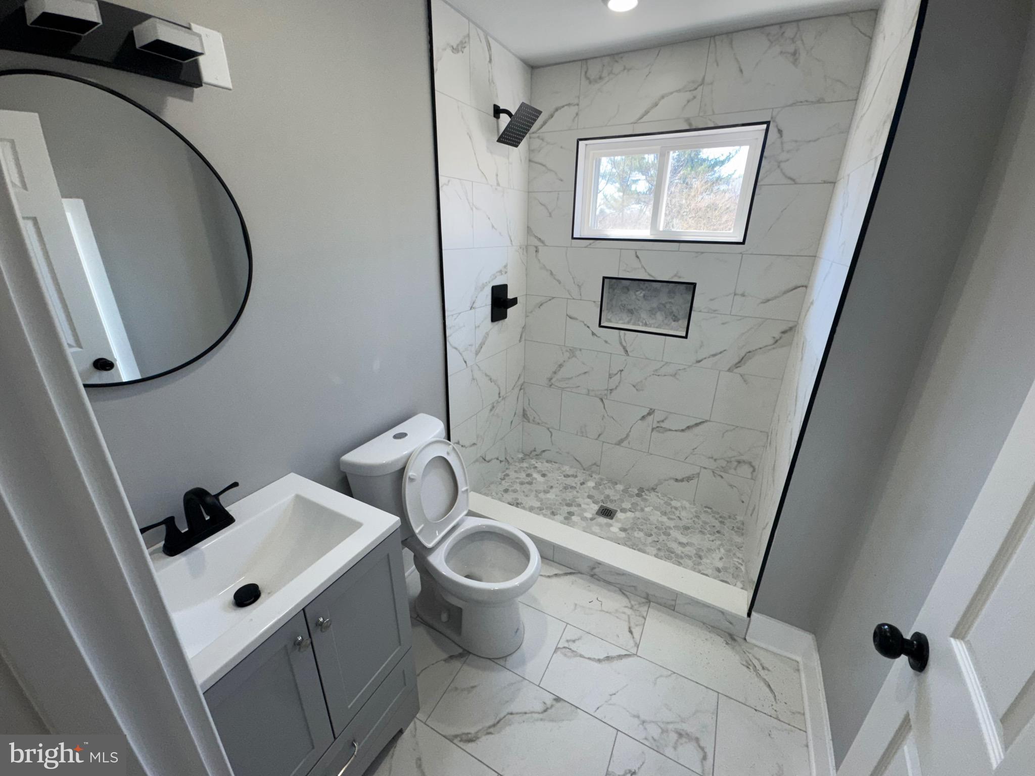 334 Church Road, Unit 2 Elkins Park, PA 19027 - Photo 23 of 38 a bathroom with a sink a toilet and a mirror