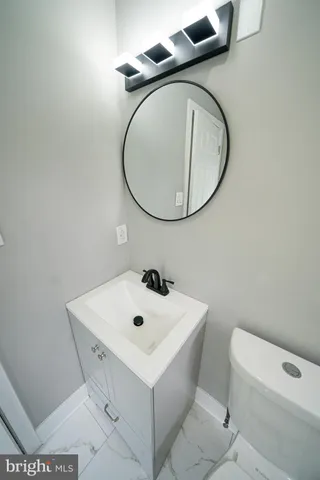 a bathroom with a sink mirror toilet and a mirror