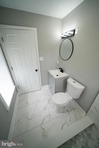 a bathroom with a granite countertop toilet a sink and a shower