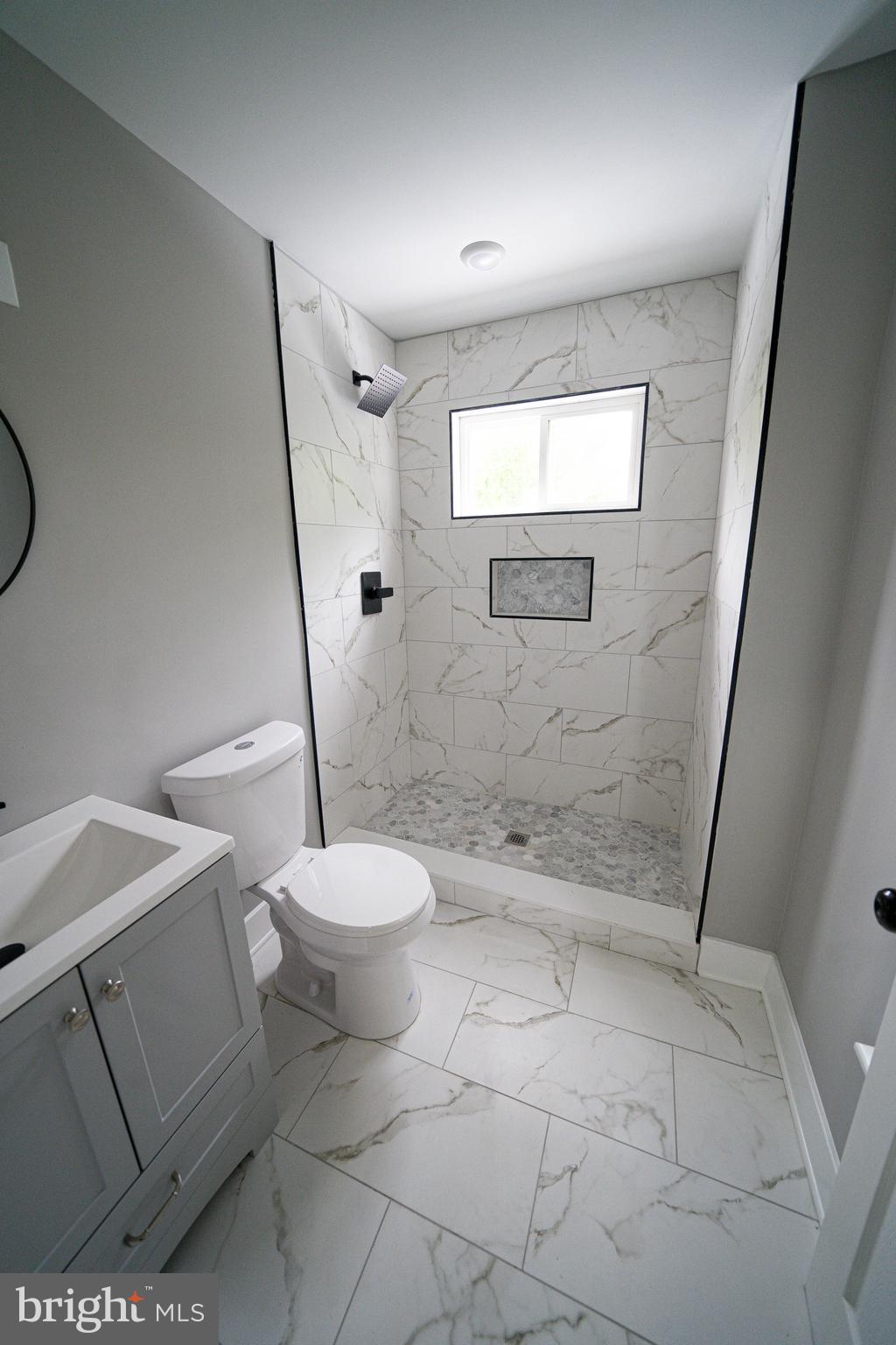 334 Church Road, Unit 2 Elkins Park, PA 19027 - Photo 29 of 38 a bathroom with a granite countertop toilet a sink and a shower