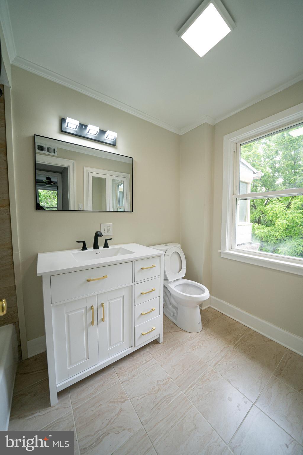 334 Church Road, Unit 2 Elkins Park, PA 19027 - Photo 33 of 38 a spacious bathroom with a toilet sink and mirror