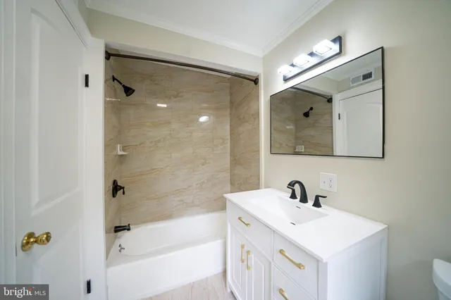 a bathroom with a bathtub shower sink and mirror