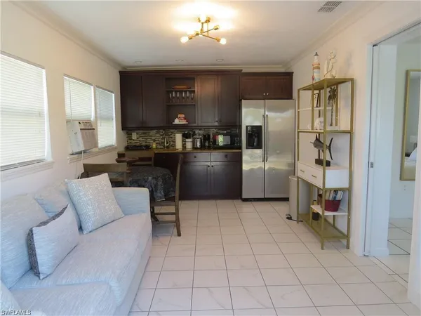 a kitchen with stainless steel appliances kitchen island granite countertop a refrigerator and a sink