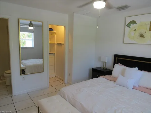 a bedroom with a bed and a painting on the wall