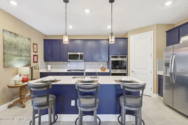 a kitchen with a sink a counter and chairs