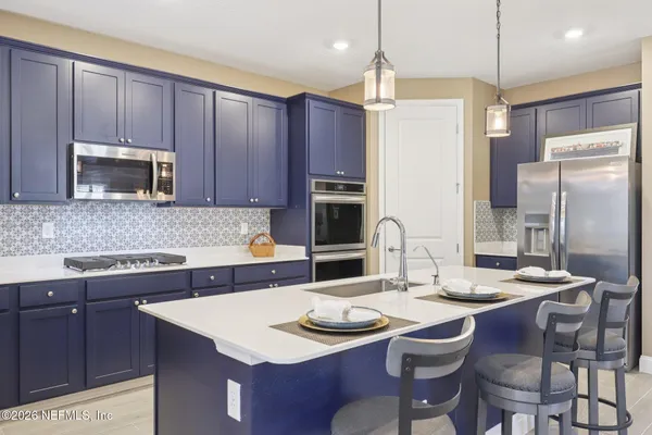 a kitchen with stainless steel appliances granite countertop a kitchen island a stove a table and chairs