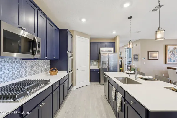 a kitchen with stainless steel appliances a sink stove microwave and refrigerator