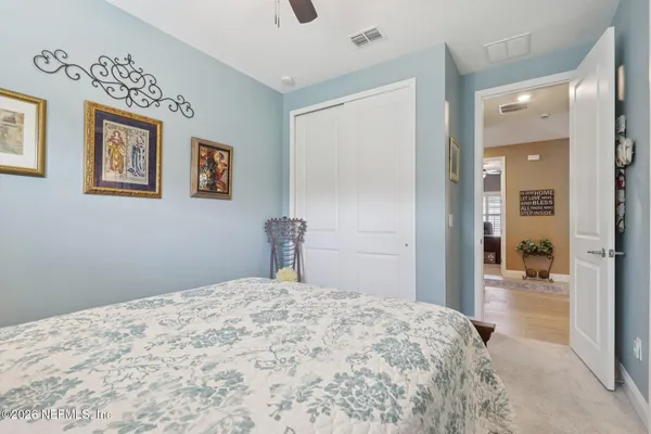 a bedroom with a bed and painting on the wall