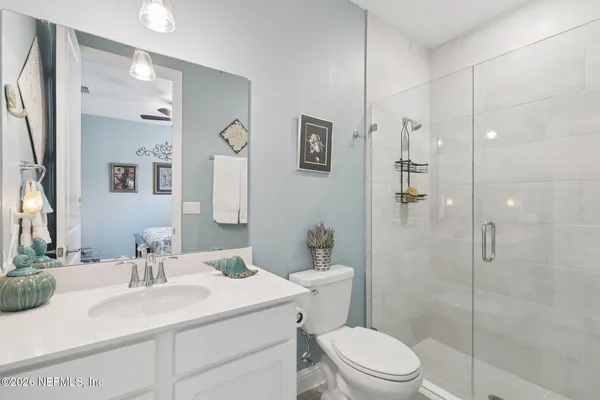 a bathroom with a sink toilet vanity and shower