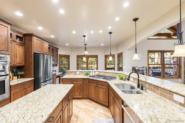 a large kitchen with kitchen island a large window a sink and stainless steel appliances