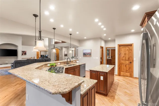 a kitchen with stainless steel appliances granite countertop sink stove and refrigerator