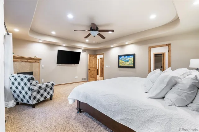 a spacious bedroom with a bed and a flat screen tv