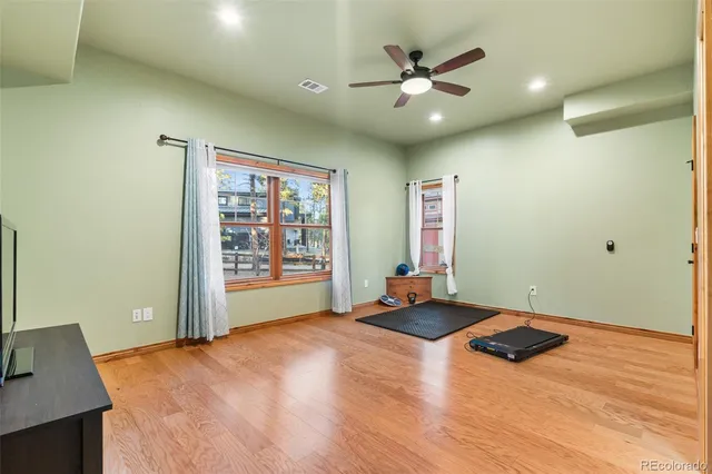 an empty room with window and ceiling fan