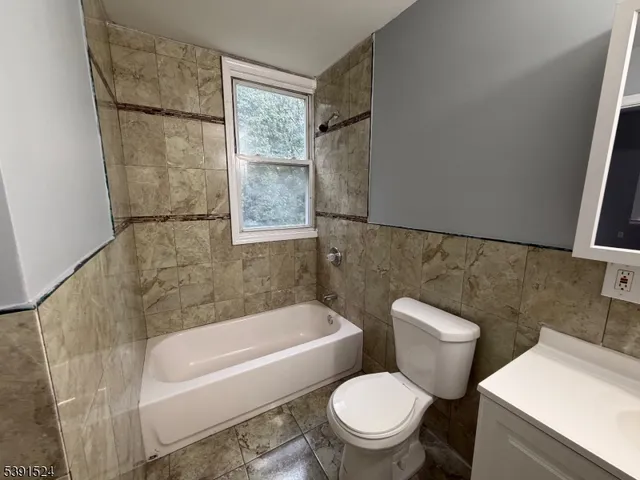 a white toilet sitting next to a bath tub