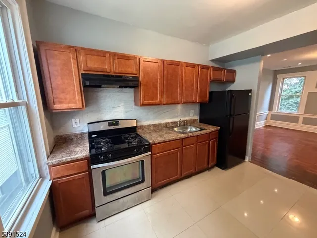 a kitchen with stainless steel appliances granite countertop a refrigerator stove and sink
