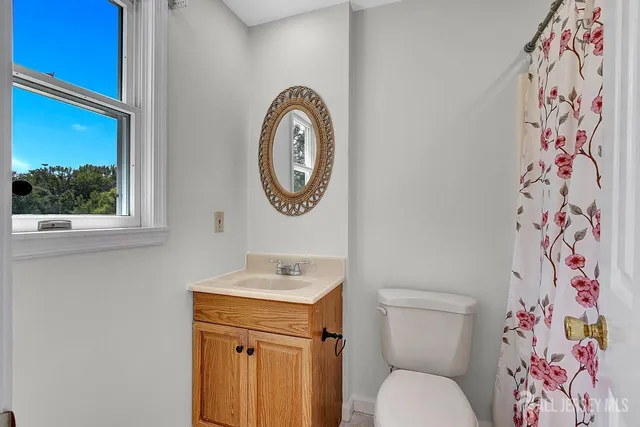 a bathroom with a toilet a sink and a window