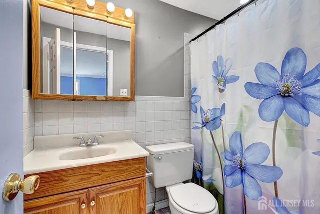 a bathroom with a sink mirror vanity and toilet
