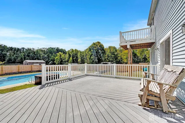 a view of a chairs on deck with wooden floor and fence