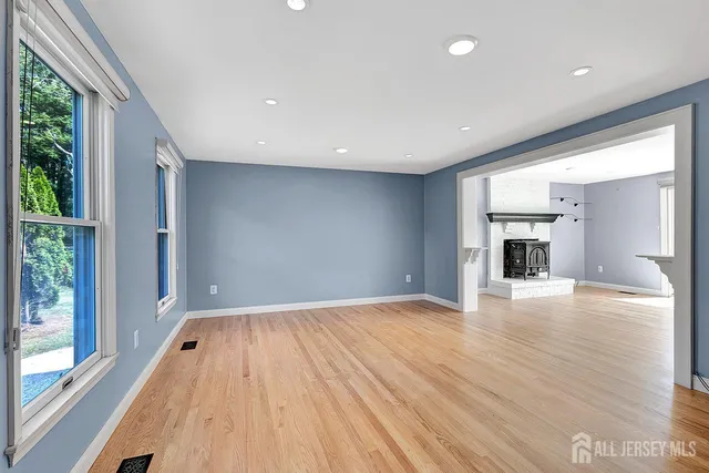 a view of empty room with wooden floor and fireplace