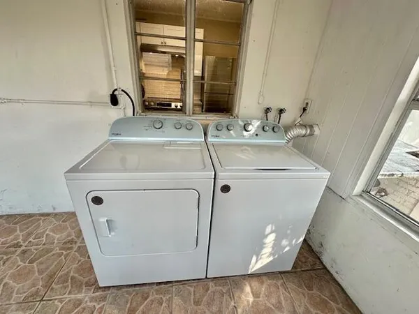 a en suite bathroom with a granite countertop sink and a large mirror next to a window