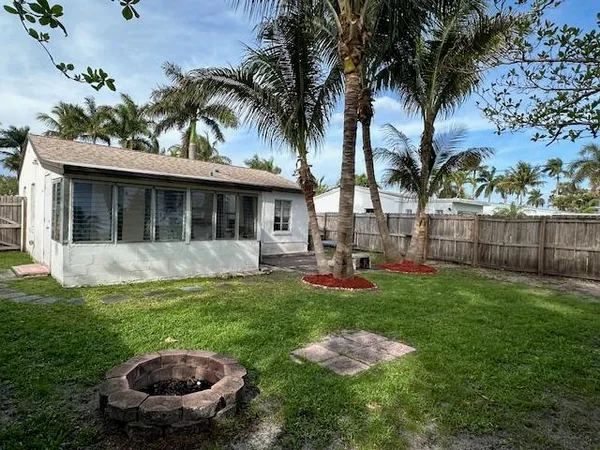 a view of empty room with wooden floor and window