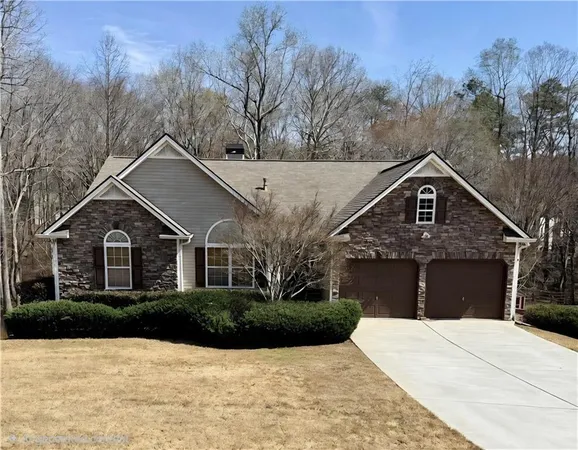 a front view of a house with a yard and trees
