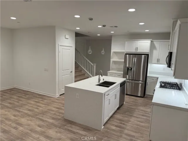 a kitchen with stainless steel appliances a sink a stove a refrigerator and cabinets