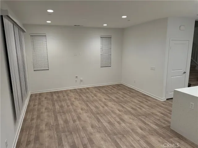 an empty room with wooden floor and window