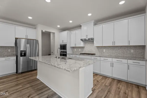 a kitchen with stainless steel appliances granite countertop a stove a sink and a refrigerator