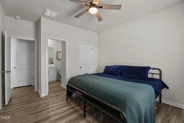 a bedroom with a bed and wooden floor