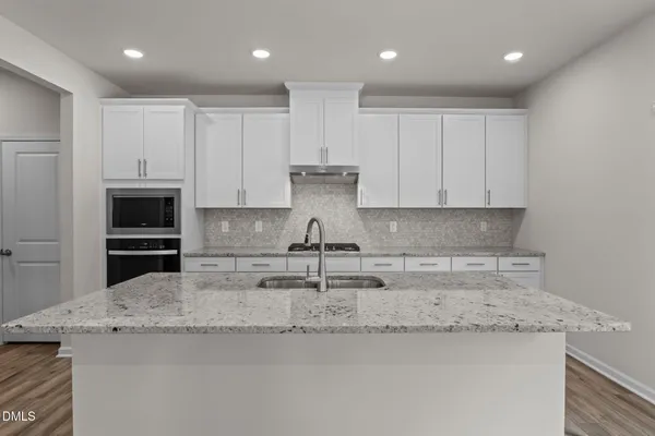 a kitchen with stainless steel appliances granite countertop a sink stove and cabinets