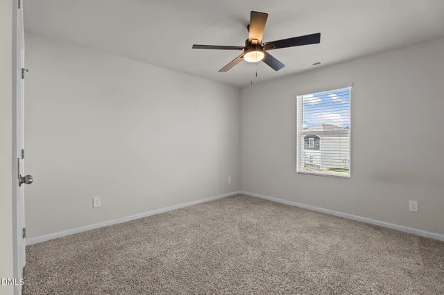 an empty room with a window and a fan
