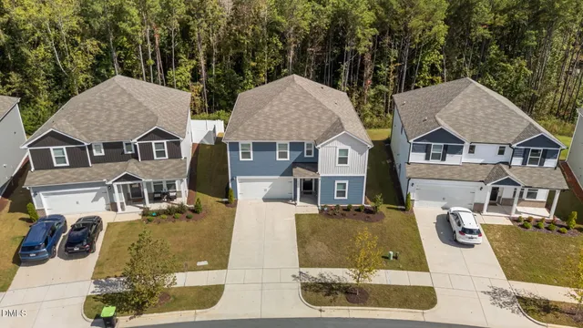 a view of a white house with large windows next to a road