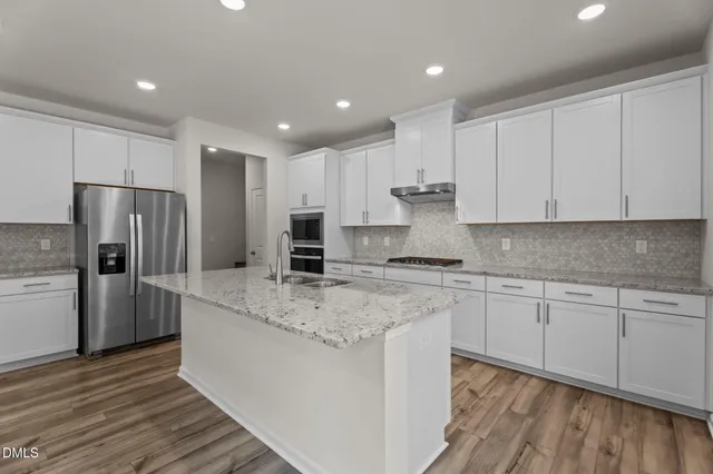 a kitchen with stainless steel appliances granite countertop a stove a sink and a refrigerator