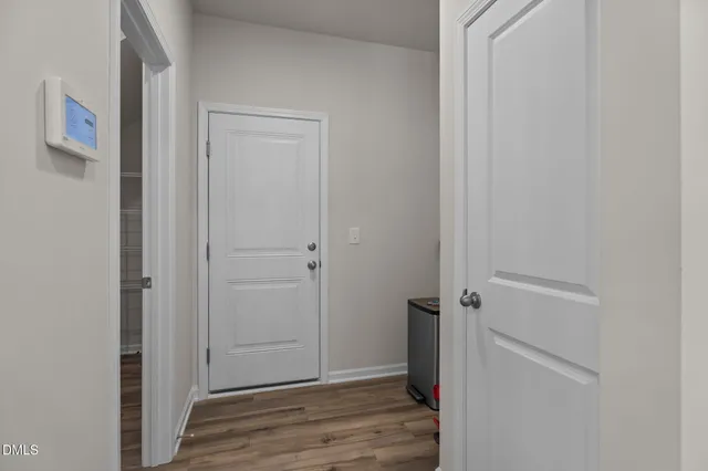 a view of a hallway with wooden floor and closet