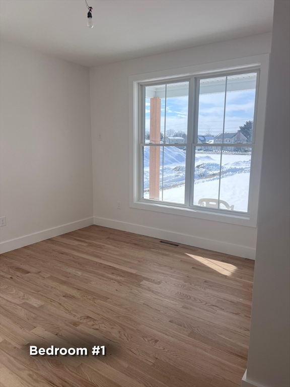 337 Chicopee Street, Unit LOT 8 Granby, MA 01033 - Photo 11 of 21 an empty room with wooden floor and windows