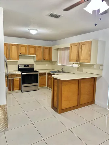 a kitchen with cabinets stainless steel appliances a sink and a window