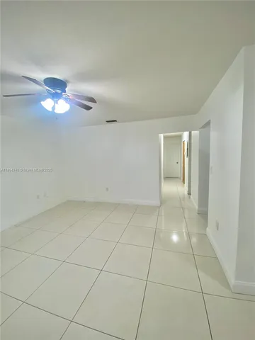 a view of an empty room with a ceiling fan