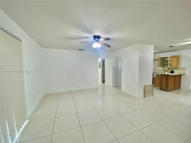 a view of an empty room with a ceiling fan