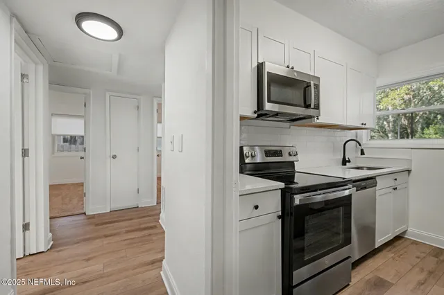 a front view of house with yard and trees in the background