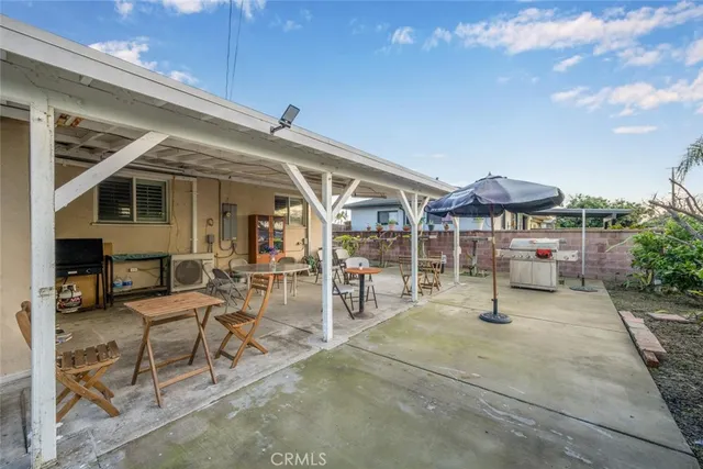a view of a patio with table and chairs under an umbrella