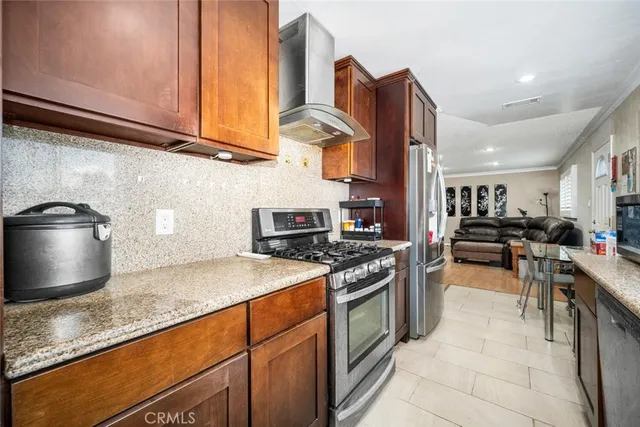 a kitchen with stainless steel appliances granite countertop a stove a sink and a microwave