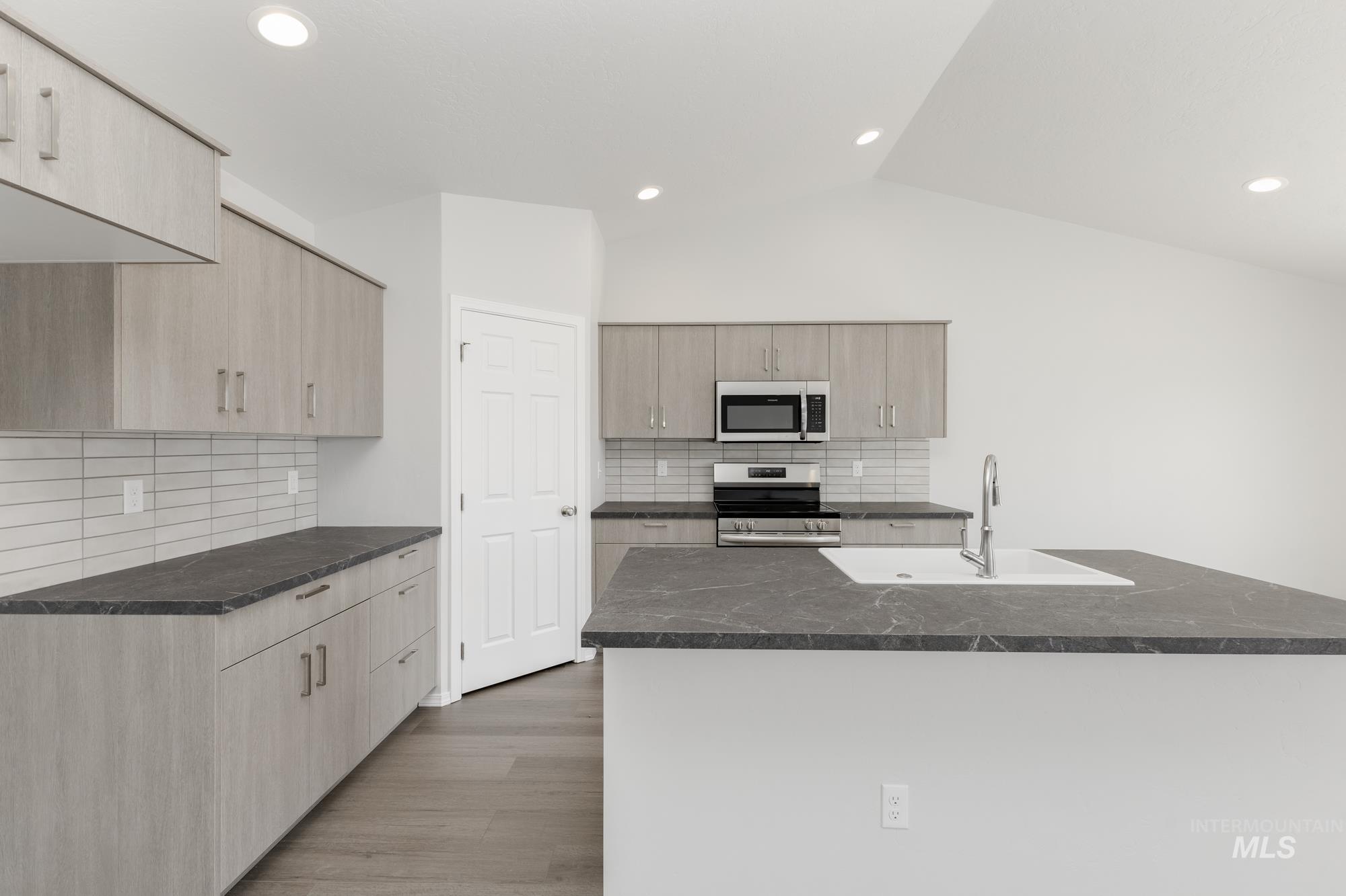 1611 Sunday River Street Middleton, ID 83644 - Photo 2 of 17 Kitchen featuring backsplash, appliances with stainless steel finishes, light wood-style floors, light brown cabinets, and recessed lighting