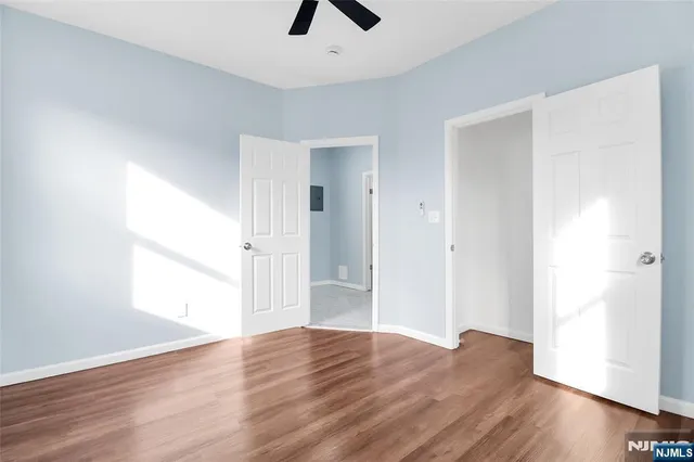 a view of empty room with wooden floor and window