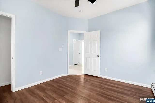 a view of an empty room with wooden floor