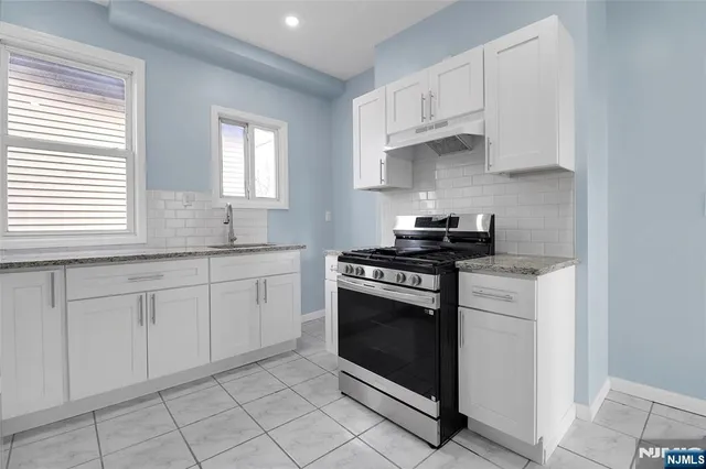 a kitchen with cabinets appliances and a window